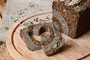 Fresh healthy rye bread next to a heart-shaped slice. Healthy food concept.