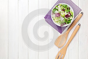 Fresh healthy salad over white wooden table