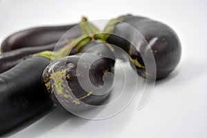 Fresh and healthy vegetables from breast, blue, purple eggplants located on a white background.