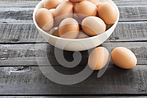 Fresh hen egg in white bowl and 2 hen egg out side on Black colo