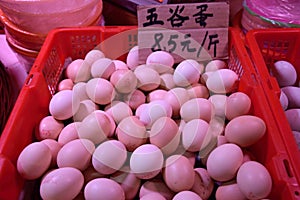 Fresh hen eggs heaped up inside the plastic basket.