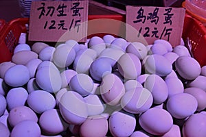 Fresh hen eggs heaped up inside the plastic basket.