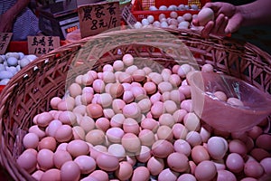 Fresh hen eggs heaped up inside the wicker basket.