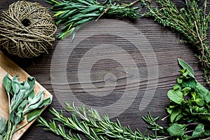 Fresh herb frame on dark wooden background top view