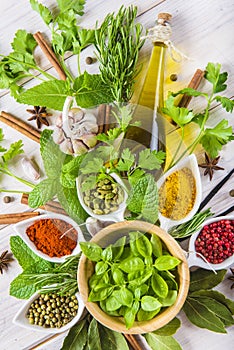 Fresh herbs and spices on a white wooden background