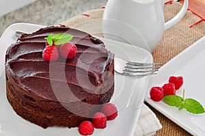 Fresh home made sticky chocolate fudge cake with raspberries
