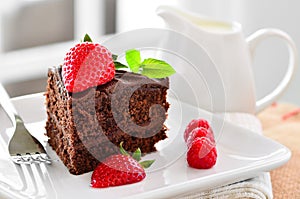 Fresh home made sticky chocolate fudge cake with strawberries and raspberries