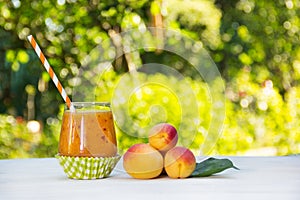 Fresh homemade apricot smoothies in the summer garden. Summer detox drinks. Refreshing drink from apricots and peaches.