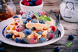 Fresh homemade belgian waffles with blueberries and raspberries for breakfast