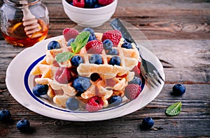 Fresh homemade belgian waffles with blueberries and raspberries for breakfast