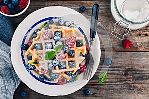 Fresh homemade belgian waffles with blueberries and raspberries for breakfast