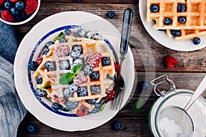 Fresh homemade belgian waffles with blueberries and raspberries for breakfast