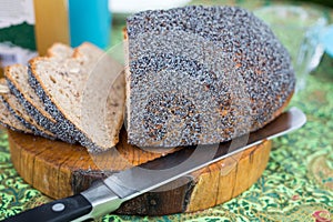 Fresh homemade bread on cutting board with knife on colorful breakfast table