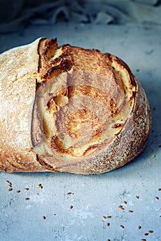 Fresh homemade bread from whole wheat and rye flour with flax seeds, pumpkin and oat flakes on a brown background. Crisp.