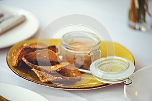 Fresh homemade chicken liver pate in a glass bowl or mold and slices of seed bread with herb and garlic pate on the table. Close-