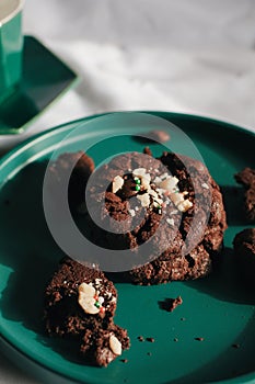 Fresh homemade chocolate chip cookies on green plate. Sweet breakfast. Stack of traditional chip cookies with chocolate chunks.