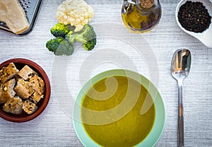 Fresh homemade creamy vegetable soup. Healthy eating - made with cauliflower potatoes, peas, celery and broccoli - wooden table -