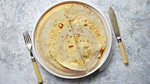 Fresh homemade crepes, thin pancakes placed on white ceramice plate