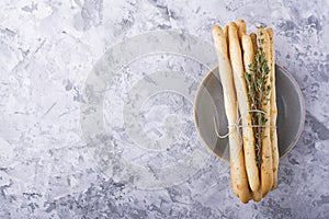 Fresh homemade crispy bread sticks with thyme and sea salt on a gray concrete background herbs. selective focus