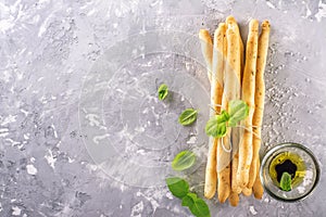 Fresh homemade crispy bread sticks with thyme and sea salt on a gray concrete background herbs