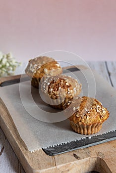 Fresh homemade delicious carrot muffins decorated with oat flakes and brown sugar on rustic table