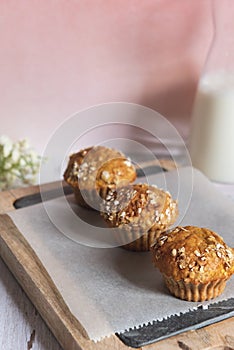 Fresh homemade delicious carrot muffins decorated with oat flakes and brown sugar on rustic table