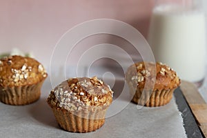 Fresh homemade delicious carrot muffins decorated with oat flakes and brown sugar on rustic table