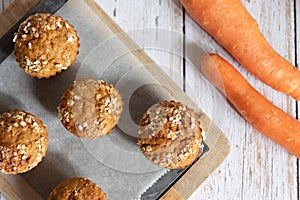 Fresh homemade delicious carrot muffins decorated with oat flakes and brown sugar on rustic table