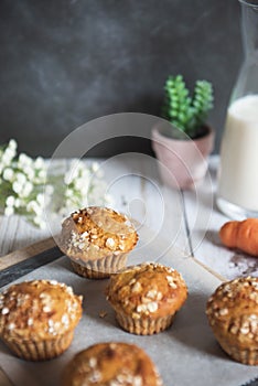 Fresh homemade delicious carrot muffins decorated with oat flakes and brown sugar on rustic table