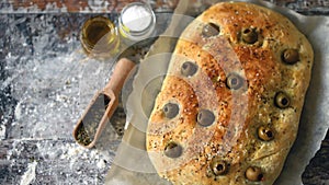 Fresh homemade focaccia with italian herbs. Cooking at home. Traditional italian bread with olives.