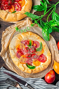 Fresh homemade galettes with tomatoes, ricotta cheese and basil