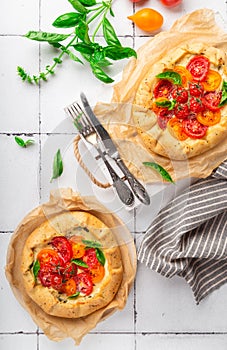 Fresh homemade galettes with tomatoes, ricotta cheese and basil