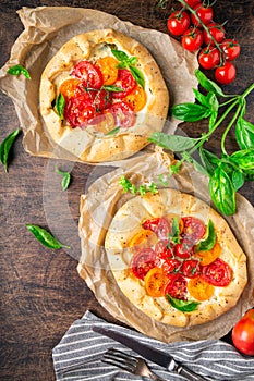 Fresh homemade galettes with tomatoes, ricotta cheese and basil