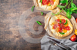 Fresh homemade galettes with tomatoes, ricotta cheese and basil