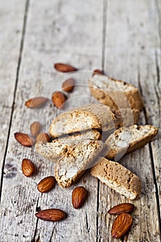 Fresh homemade Italian cookies cantuccini heap and almond nuts on ructic wooden table