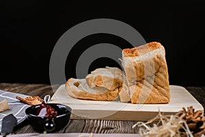 Fresh homemade loafs bread and sliced bread on cutting board with jam strawberry close up on wooden background.Healthy Diet.Prepar