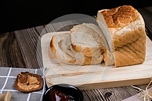 Fresh homemade loafs bread and sliced bread on cutting board with jam strawberry close up on wooden background.Healthy Diet.Prepar