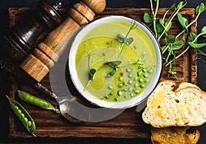 Fresh homemade pea cream soup in bowl with grilled bread