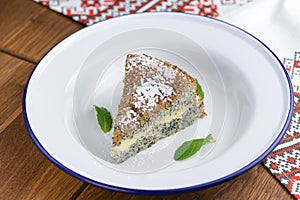 Fresh homemade poppy seed cake with vanilla cream and powdered sugar.