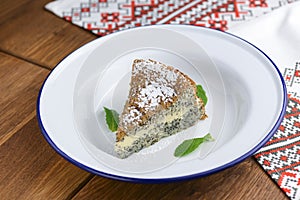 Fresh homemade poppy seed cake with vanilla cream and powdered sugar.