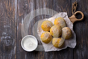 Fresh homemade pumpkin buns yeast-free with cardamom sprinkled with icing sugar on wooden board