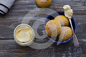 Fresh homemade pumpkin cardamom buns yeast-free with cream sprinkled with icing sugar on wooden board