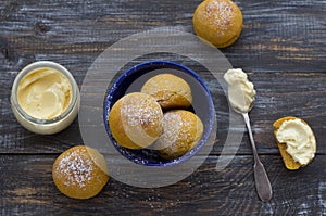 Fresh homemade pumpkin cardamom buns yeast-free with cream sprinkled with icing sugar on wooden board