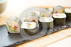 Fresh Homemade Sushi Roll. Fried sushi on black slate surface. Japanese food