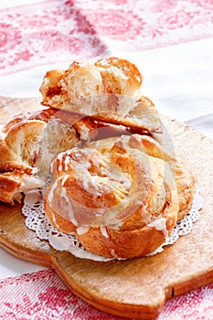 Fresh homemade sweet cinnamon swirl bun with glaze. Selective focus