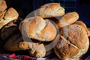 Fresh homemade whole-grain bread displayed for sale in a black plastic baskets at a street food market, selective focus