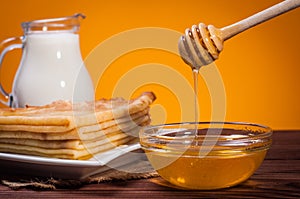 Fresh honey with a Stack of blinis or crepes