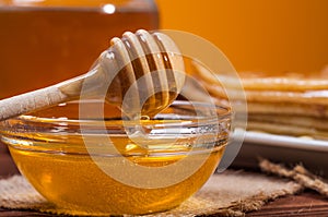 Fresh honey with a Stack of blinis or crepes