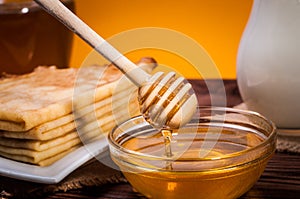 Fresh honey with a Stack of blinis or crepes