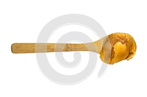 Fresh honey in a wooden spoon isolated